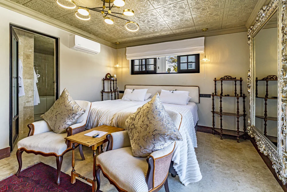 Luxury Apartment bedroom with a double bed and armchairs
