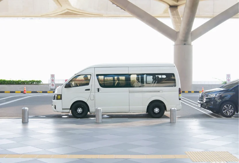 airport shuttle lr White minibus shuttle parked at a kerb