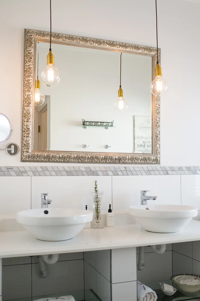 peartree_batavia-56 Bathroom vanity with a large gilt-framed mirror