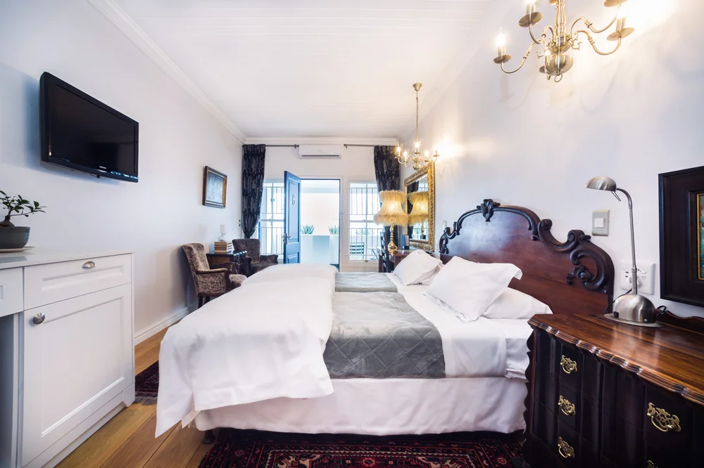 peartree_batavia-61 Bedroom with a carved wooden headboard and wall-mounted TV